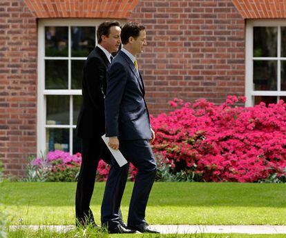 El primer ministro británico, David Cameron (en segundo plano), y el viceprimer ministro, Nick Clegg, se dirigen a una rueda de prensa en los jardines de Downing Street, el pasado miércoles.