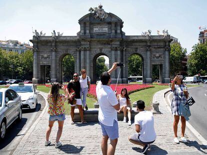 Unos turistas se fotografían ayer en la Puerta de Alcalá.