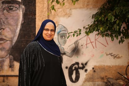 Rania Wasfi, responsable de recursos humanos y relaciones públicas del 'Freedom Theatre', junto a uno de los murales de la entrada del centro