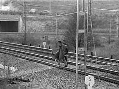 Dos toxicómanos cruzan la vía, en Pitis, para ir a comprar droga al pobaldo de La Quinta, en una imagen de archivo.