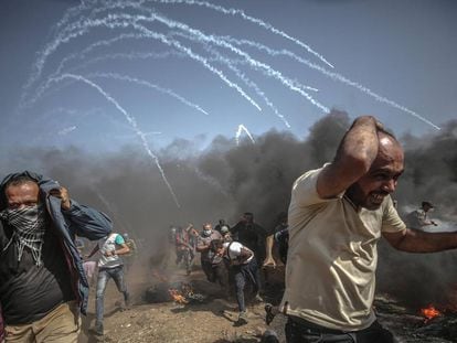 Varios palestinos corren para refugiarse de un ataque de las fuerzas israelíes.
