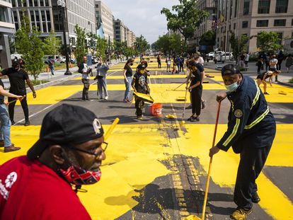 Varios voluntarios pintan el lema Black Lives Matter en el último tramo de la calle 16.