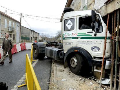 Un vecino de Loiro junto al cami&oacute;n empotrado en una vivienda 