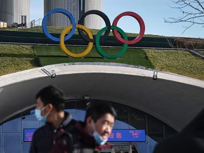 Personas caminan frente a la torre de los Juegos Olímpicos de Pekín, el pasado diciembre.