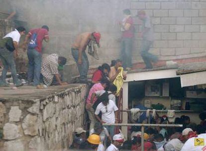 Las fuerzas de seguridad lanzan gases lacrimógenos a los simpatizantes de Zelaya afuera de la embajada de Brasil en Tegucigalpa