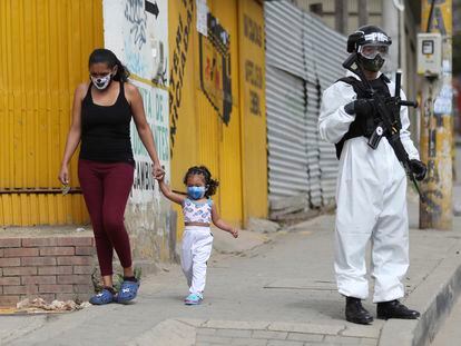 Un soldado con un traje para la covid vigila una calle de Ciudad Bolívar, uno de los barrios más afectados por la pandemia en Bogotá.