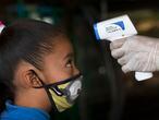 Un sanitario toma la temperatura a una niña en la Ciudad de México.