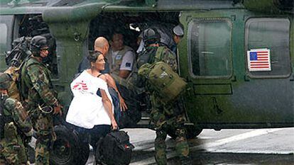 Varios periodistas y miembros de ONG embarcan en un helicóptero estadounidense para salir de la capital liberiana.