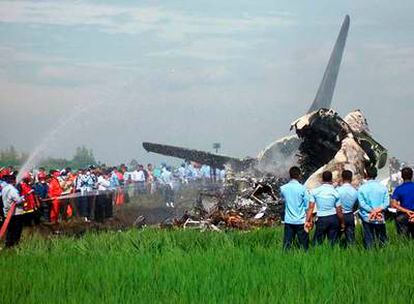 Bomberos del aeropuerto de Yogyakarta echan agua sobre los restos de Boeing 737 que se incendió causando al menos 49 muertos.