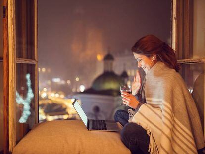 Una mujer comparte una copa de vino por videollamada.