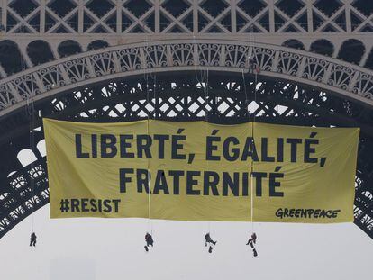 Una docena de activistas de Greenpeace han desplegado una pancarta de 300 m² desde la Torre Eiffel.