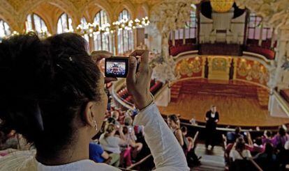 Una turista capta con su cámara fotográfica la sala central del Palau de la Música.