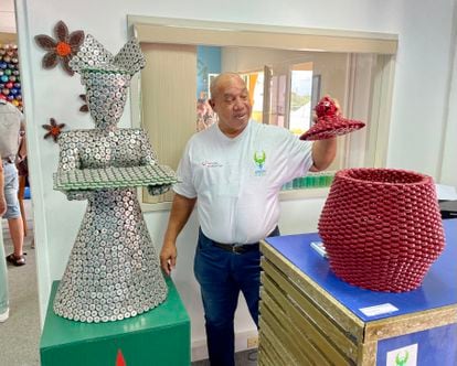 The artist Erwin Sprot next to two of his works, at the Green Phenix facilities in Curaçao.
