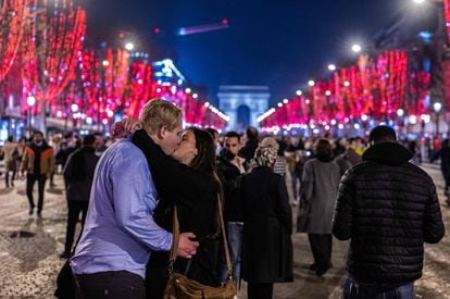 Una pareja se besa en los Campos Elíseos de París (Francia), esta madrugada.