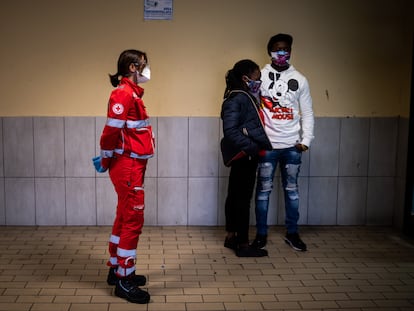 Un voluntario de la Cruz Roja espera en el departamento de emergencias del hospital para que los médicos visiten a una pareja de inmigrantes.