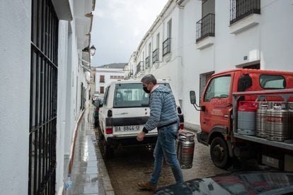 Un butanero deposita una bombona de gas en la entrada de una casa de Herrera del Duque.