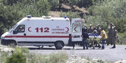 Soldados turcos trasladan a un refugiado sirio que llegó herido a la ciudad fronteriza de Güveçci.