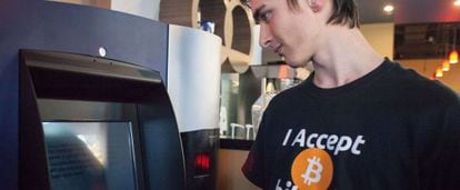 Un cliente del café The Waves (Vancuver) observa el primer cajero de bitcoins.