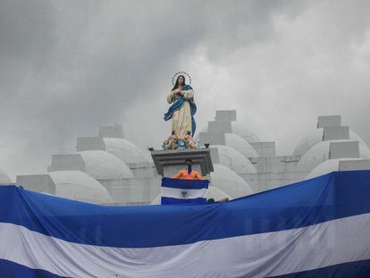 Un joven sostiene una bandera de Nicaragua en el techo de una catedral durante una protesta, en mayo de 2019.