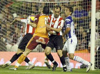 Sorrentino bloca el balón acosado por Etxeberria, al que marca Beto.