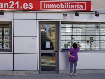 Una mujer mira el escaparate de una inmobiliaria en Sevilla, el pasado 4 de mayo.