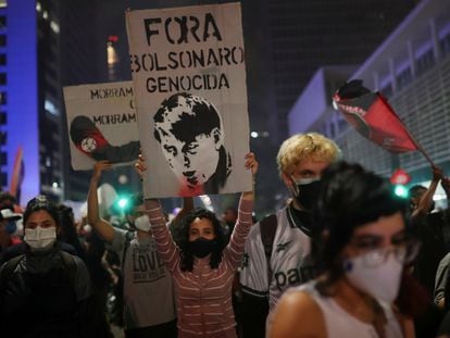 Una manifestante marcha con un cartel que dice "Fuera Bolsonaro genocida" este sábado en la avenida Paulista de São Paulo.