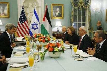 Kerry come con los negociadores de Oriente Medio en 2013.