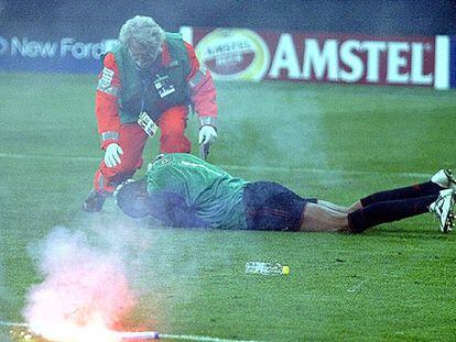 El portero del Milan, Dida, cae al suelo tras recibir el impacto de una bengala.