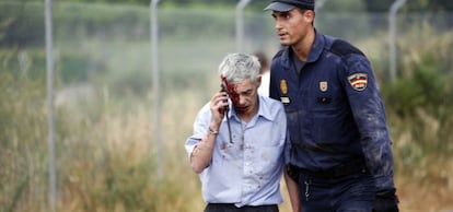 El maquinista del tren de Santiago, escoltado por un policía, tras el accidente.
