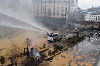 Un camión con cañones de agua a presión es utilizado por la policía durante la protestas de agricultores en Bruselas, este lunes. 