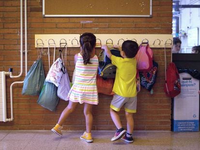 Dos niños hacen cuelgan sus mochilas en la Escola Catalonia de Barcelona. 