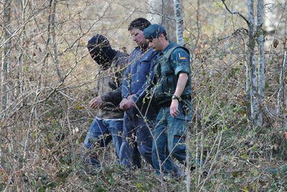 El presunto terrorista Aitor Esnaola es conducido por dos agentes para localizar zulos de ETA.
