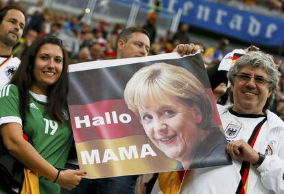 Dos seguidores alemanes sujetan un póster con la foto de Angela Merkel que pone: "Hola mamá".