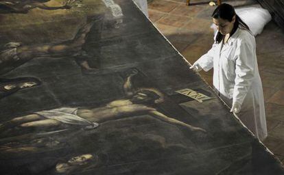Una restauradora monta la tela para instalarla en su iglesia de Girona.