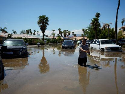 Un hombre vuelve a su casa por una calle inundada, a causa de la tormenta tropical 'Hilary', en Cathedral City, este lunes en California.