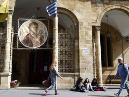 Varias personas pasan delante de la iglesia Panayia Phaneromeni en el centro de Nicosia (Chipre). La Iglesia de Chipre puso esta semana sus bienes a disposición del estado para intentar evitar el rescate de la UE.