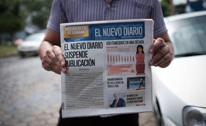 Un hombre muestra la primera plana de 'El Nuevo Diario' que anuncia la decisión del periódico de echar el cierre.
