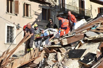 Los equipos de emergencia rescatan a un hombre que ha quedado atrapado entre los escombros causados por un terremoto en Arquata del Tronto (Italia).