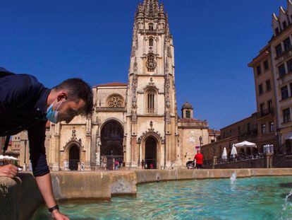 Un turista se refresca en la fuente de la catedral de Oviedo