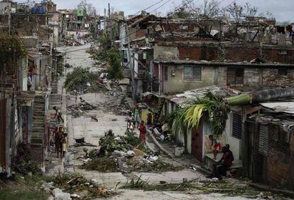 Los vecinos inentan amontonar los escombros y arbolado que el huracán Sandy ha provocado en Santiago de Cuba.