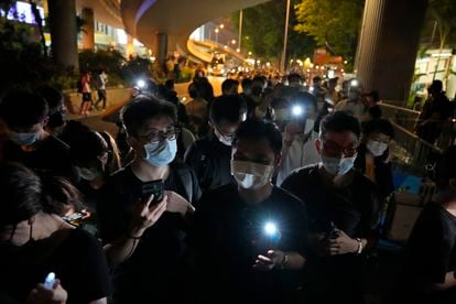 Varios hongkoneses encienden velas y las luces de sus móviles para recordar la matanza de Tiananmén, este viernes fuera del parque Victoria de Hong Kong.