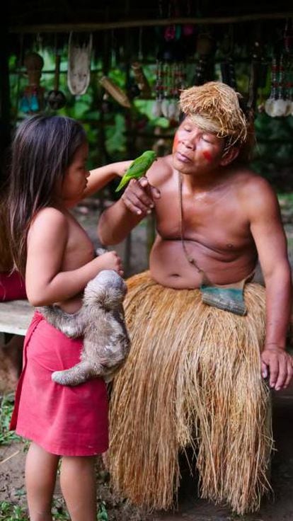 Un hombre Yagua con su nieta en una réplica de un pueblo Yaguas en la Amazonía peruana.