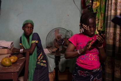 Awa Baguia junto a una niña de 12 años de una familia de desplazados internos, en marzo de 2021, dentro de su casa, en Uagadugú, Burkina Faso.