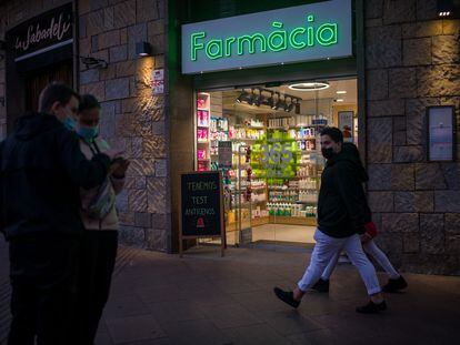 Varias personas pasan al lado de una farmacia, el 3 de enero en Barcelona.