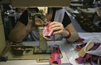 Una mujer cose unas sandalias en una fábrica de calzados en Monóvar (Alicante).
