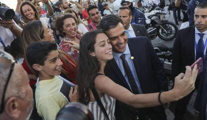 Pedro Sánchez se hace una foto con una turista durante un paseo por Lisboa.