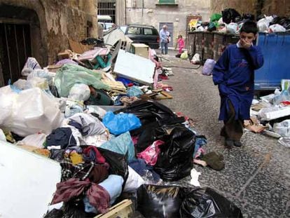 Un niño atraviesa una calle de Nápoles llena de basura.