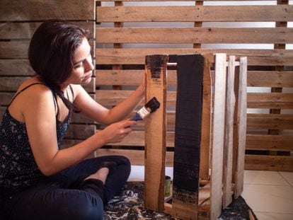 Una mujer pinta una caja de madera. Las expectativas del sector del bricolaje son de crecimiento, entre otras razones por la influencia creciente de las redes sociales.