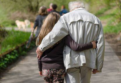 Una nieta camina agarrada de su abuelo.