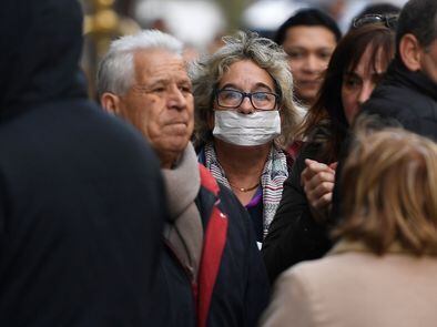 En foto, una persona pasea con una mascarilla por Madrid. En vídeo, se superan los 100.000 casos de coronavirus en el planeta.